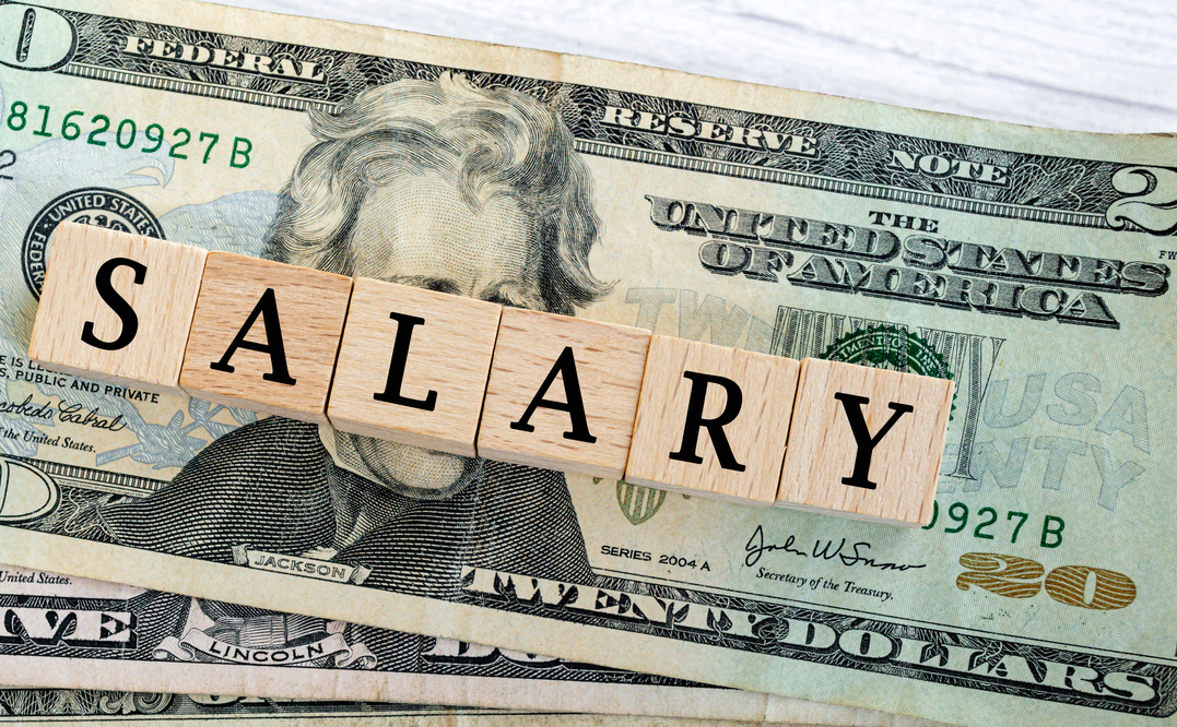 Salary word written on wood block with American Dollar-bills